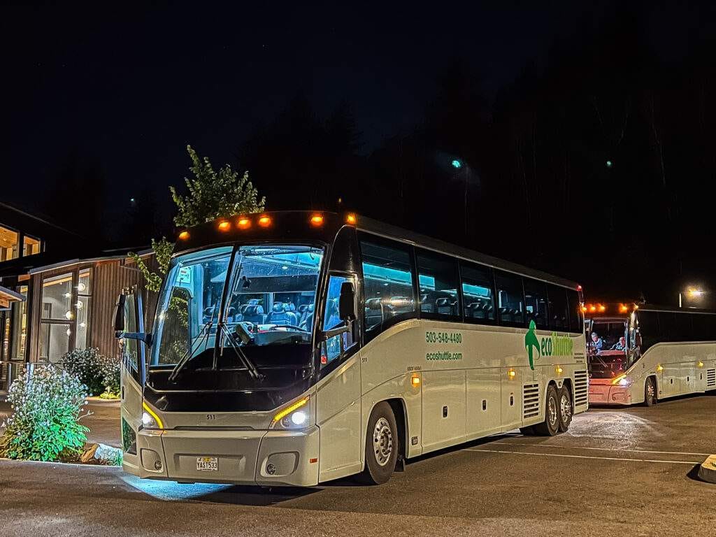 A charter bus picking up at night.