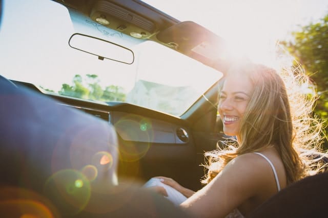 A woman smiling while sitting in a car