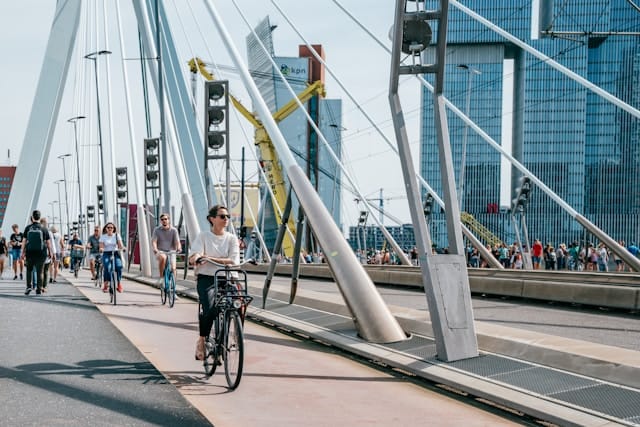  People biking along a bike lane on a bridge. 