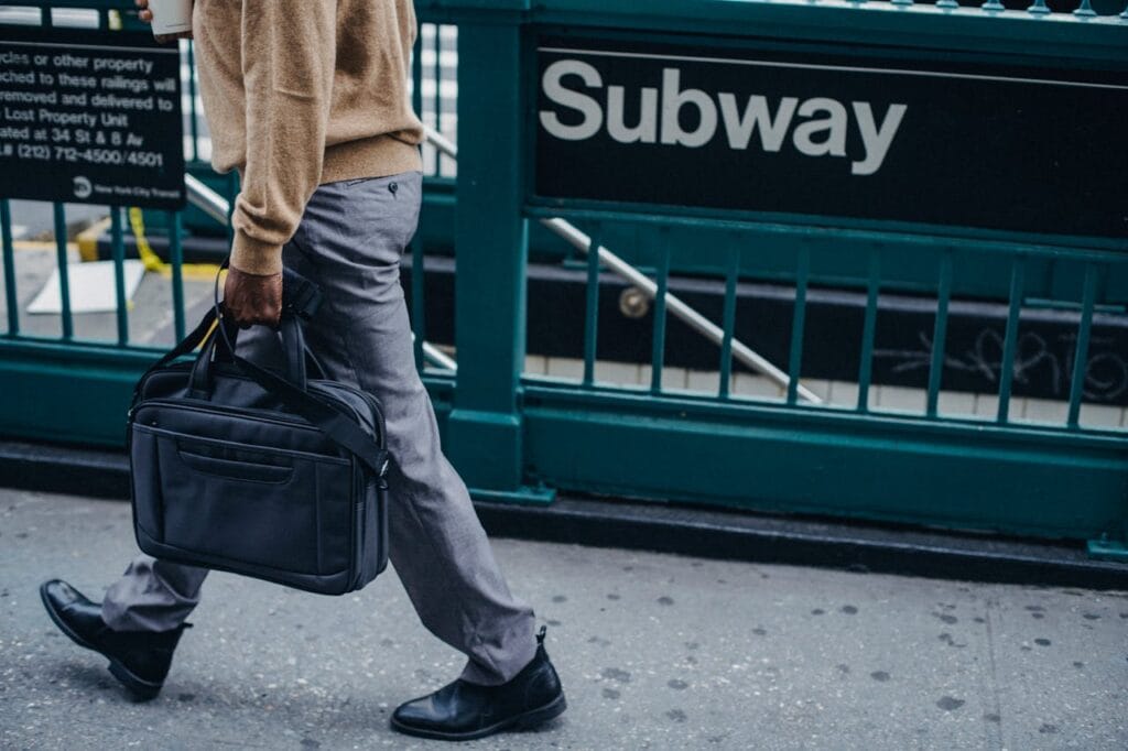 Man walking with a briefcase near a subway station