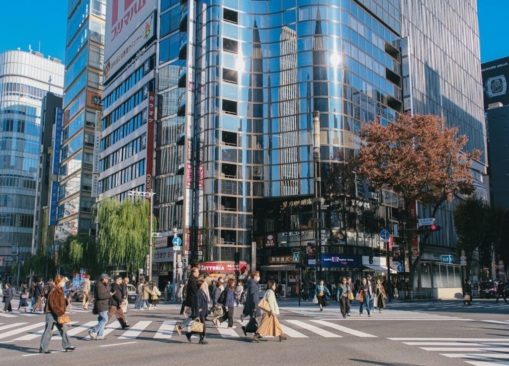 Busy intersection with glass buildings, pedestrian crossings, people